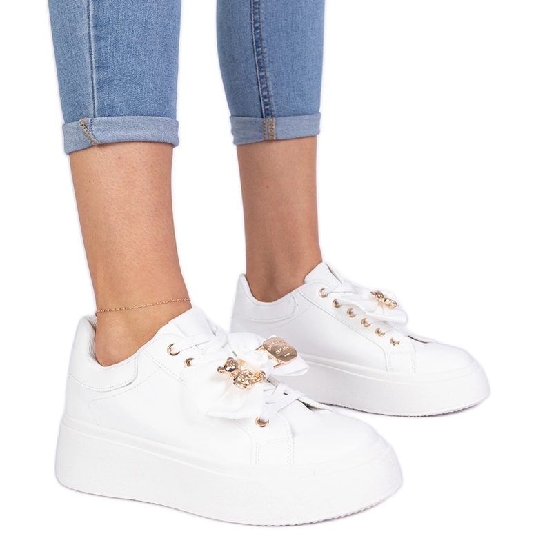Bijele tenisice ukrašene lukom i zlatnim medvjedićima bijela