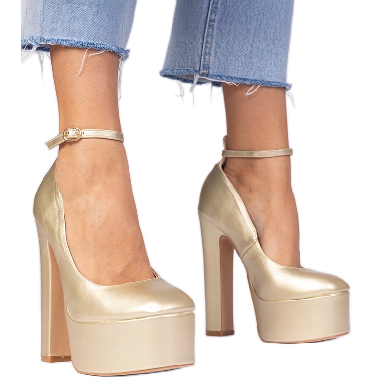 Zlatne metalne pumpe na visokoj posta zlatna
