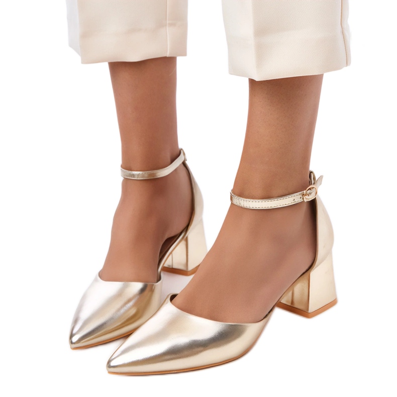 Zlatne pumpe na post pričvršćene na kerisovim kockama zlatna